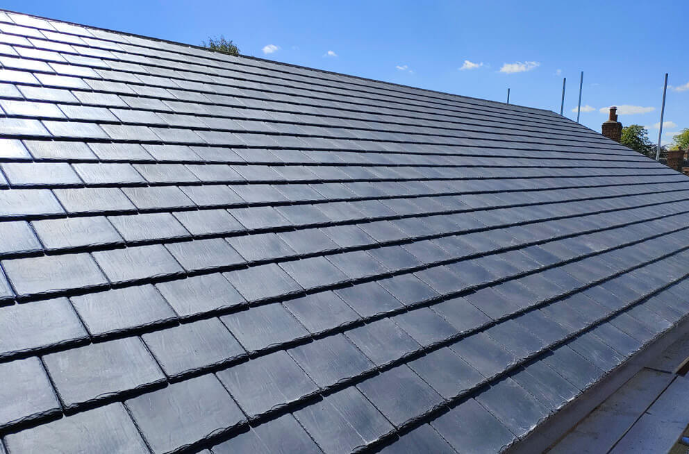 Slate roof installation beneath a blue sky