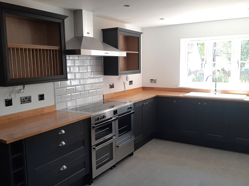 Completed dark kitchen with timber worktops